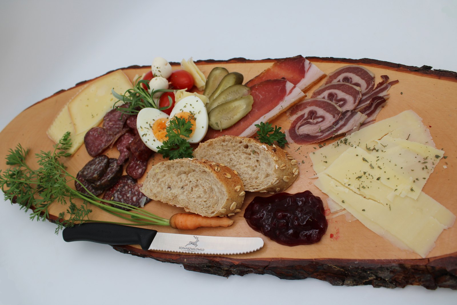 Vesperplatte mit Wildwurst, Schinken und Käse von Schwarzwaldwild Hevart auf einer Baumscheibe